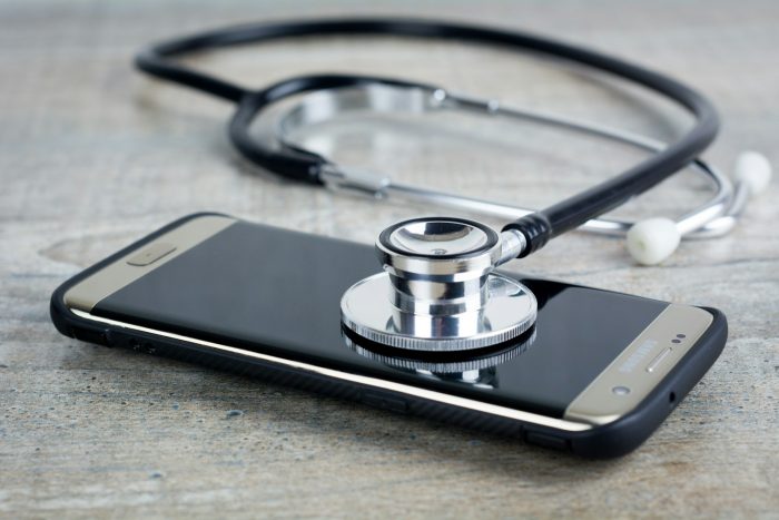 smart phone with a stethoscope on top of it