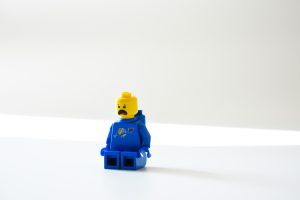 blue lego toy with sad face