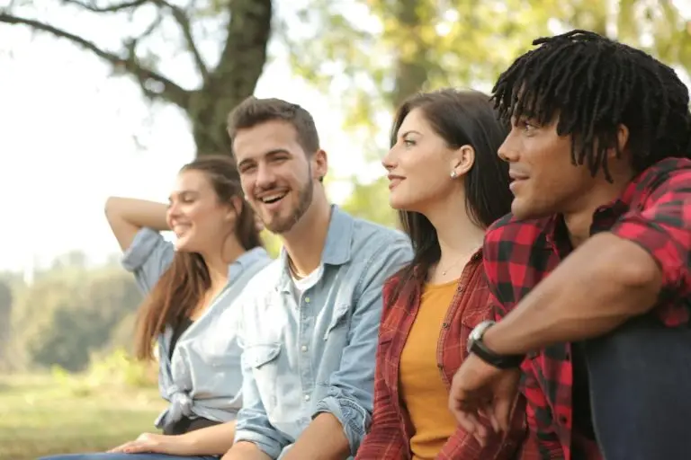 Happy diverse couples laughing in park