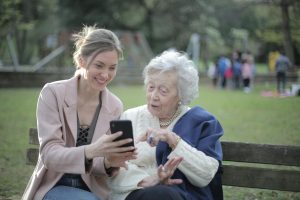 women sitting together on park bench