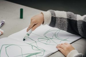 Child drawing messy picture with green marker