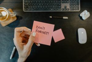 woman holding a note that says don't forget