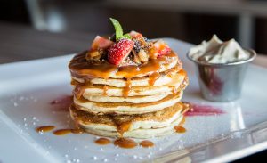 pancakes with strawberries and syrup on a plate