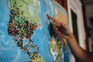 person pointing at a map with pins