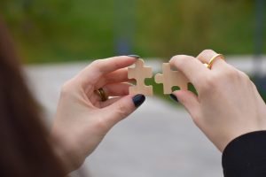 person holding 2 puzzle pieces together