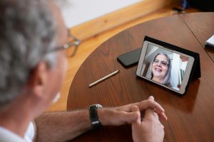 Senior man having a video call with a woman using smartphone