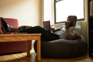 A man working on a laptop sitting on recliner