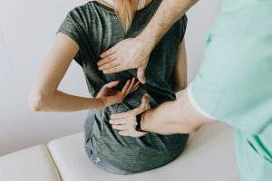 practitioner examining a patient's back pain