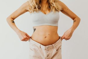 A woman displaying weight loss by wearing oversized pants