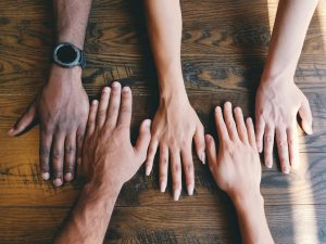 five human hands on table