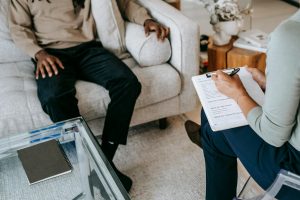 male sitting on couch having a consultation with their practitioner