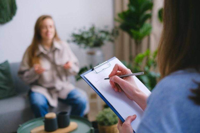 Patient with practitioner taking notes on clipboard