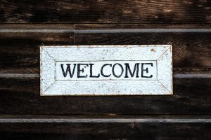 A rustic vintage-style 'Welcome' sign on a wooden wall