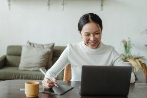 woman uses a laptop and tablet for a video call