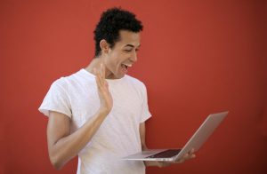 Young man making a cheerful video call on a laptop
