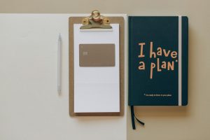 Office setup featuring a planner, clipboard and pen