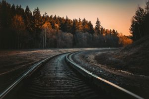 railway track in a forest at autumn sunset