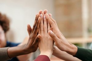 Close-up of diverse group hands high-fiving