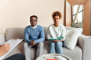Couple sits on a sofa during a therapy session