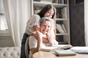 Granddaughter hugging her grandma at home