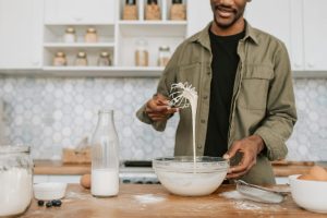 Man in kitchen mixing batter in bowl