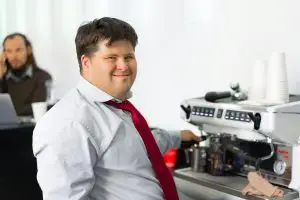 Man smiling while making coffee at work