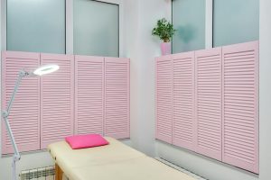 Pink treatment room featuring a massage table