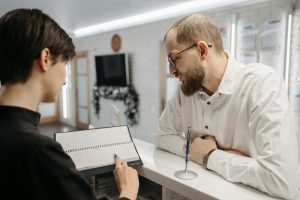 Receptionist and client speak at a clinic reception desk