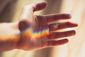 A hand with a beautiful rainbow light refraction
