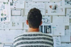 Man stands in front of a wall filled with creative ideas and plans