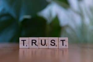 Wooden letter tiles spelling TRUST