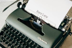 Classic green typewriter with paper displaying 'Review'