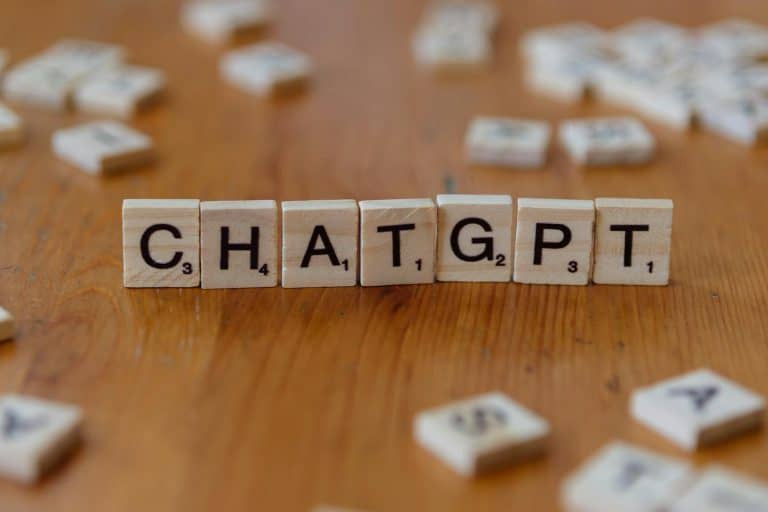 Wood tiles spelling "CHATGPT" on wooden surface