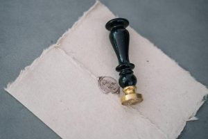 Close-up of a vintage wax seal on a rustic paper