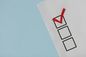 White paper checklist with one red checkmark