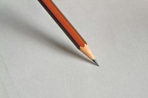 Detailed close-up of a wooden pencil resting on white paper